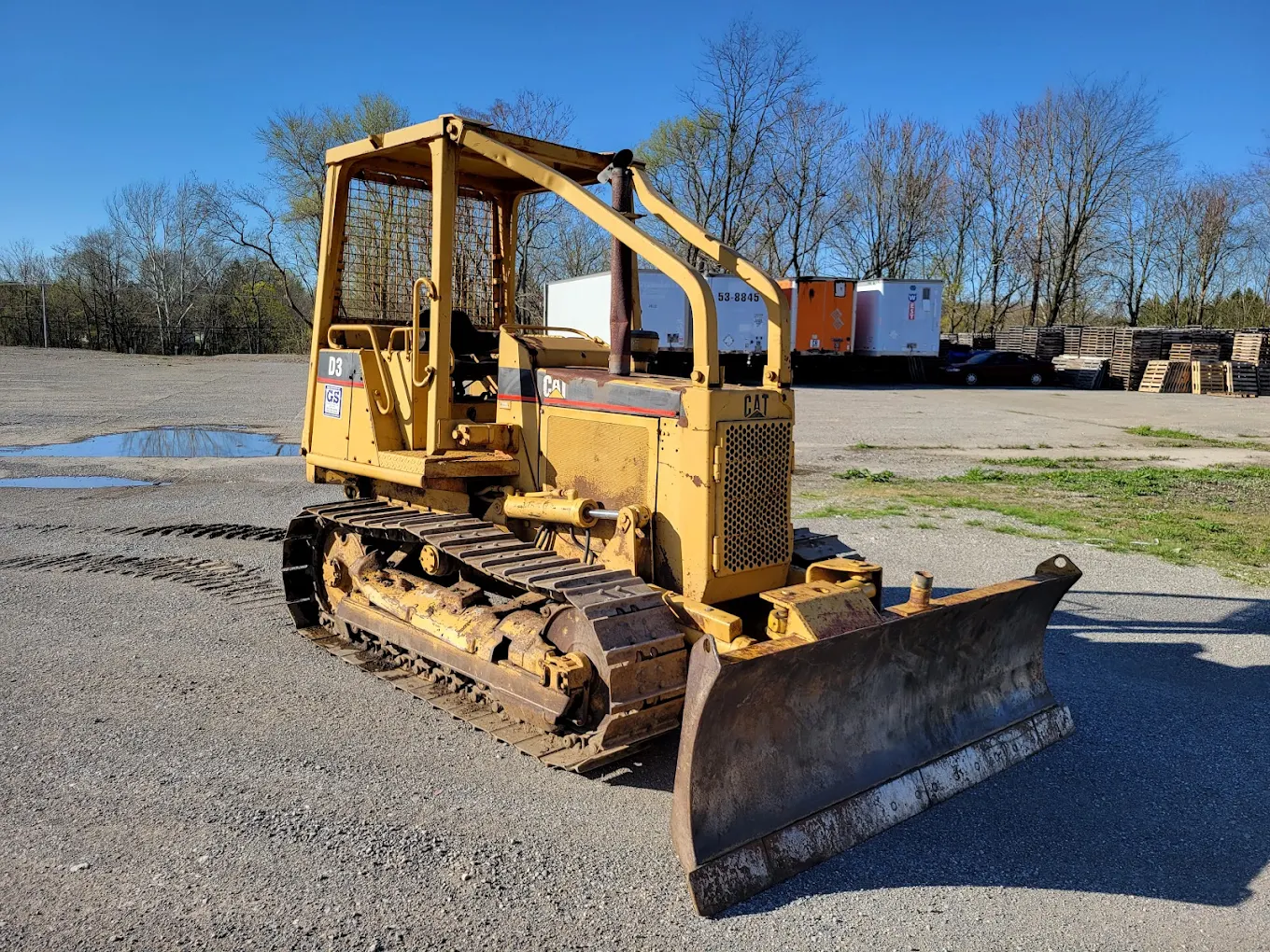 Yellow Caterpillar crawler dozer with front blade at an equipment yard